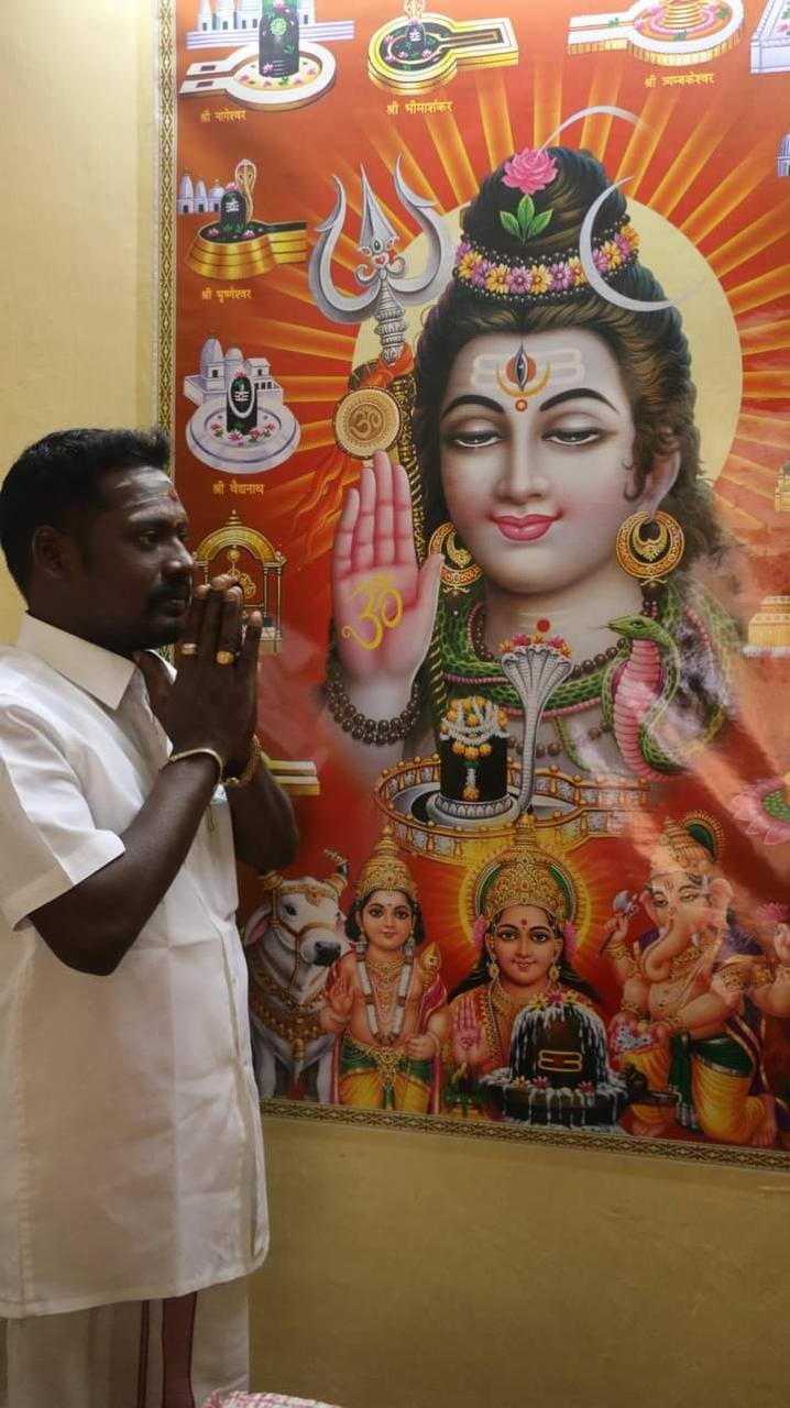Guruji in prayer before a portrait of Lord Shiva